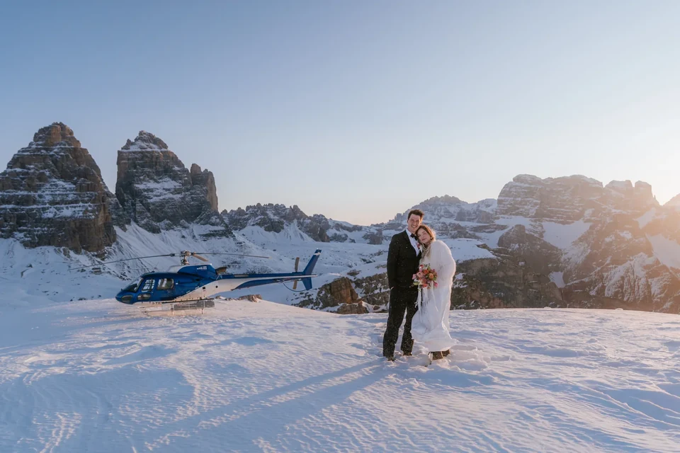 The couple with the helicopter on a snowy plateau at last light