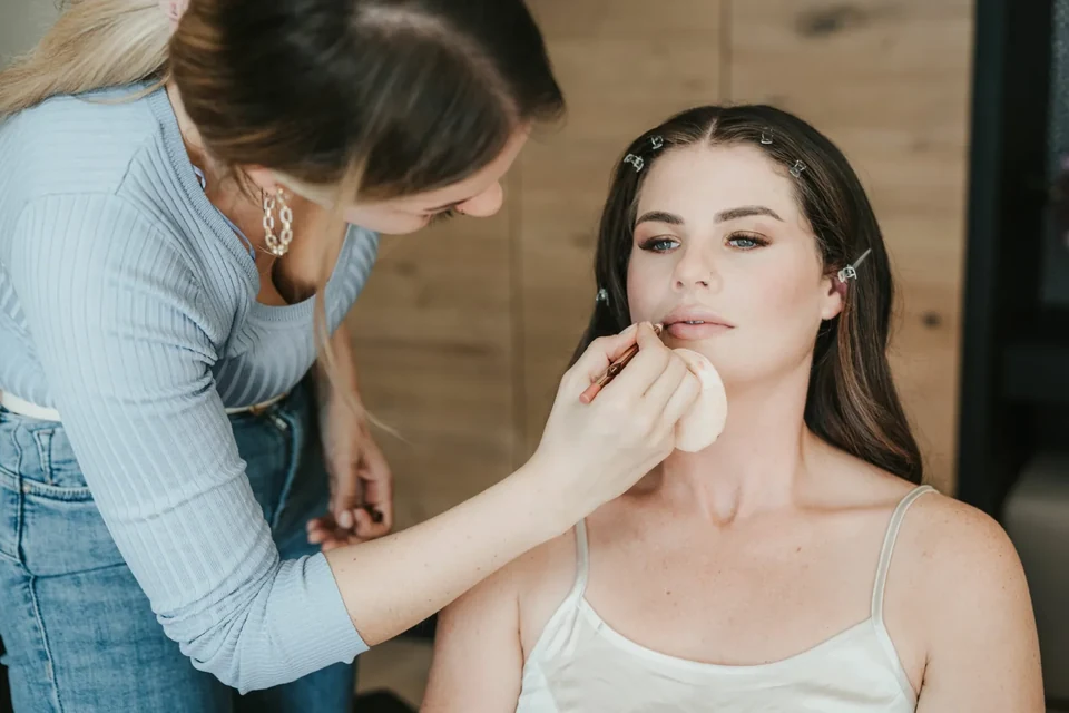 The bride having make-up applied during getting ready