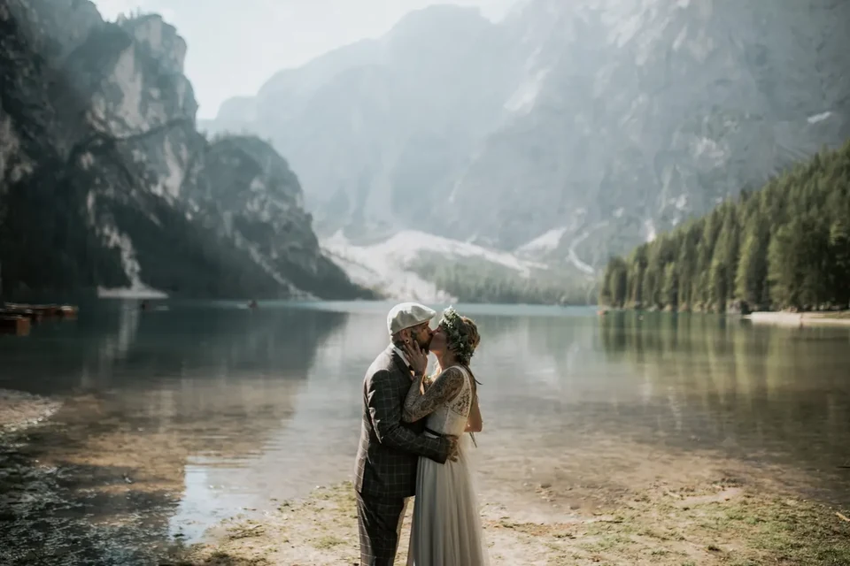 A couple embracing at a misty Dolomite lake on their elopement day