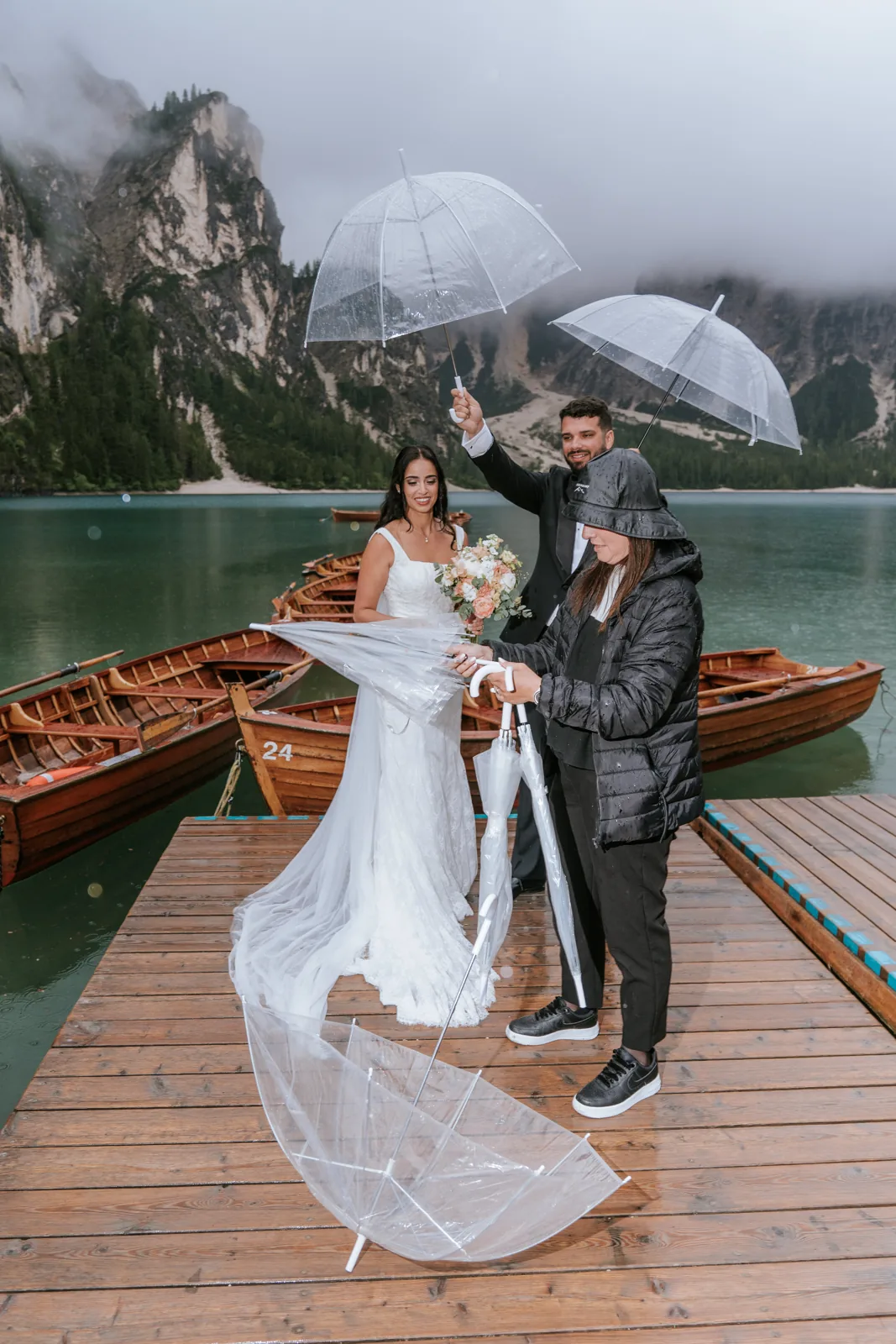 The couple under an umbrella on a jetty in the rain