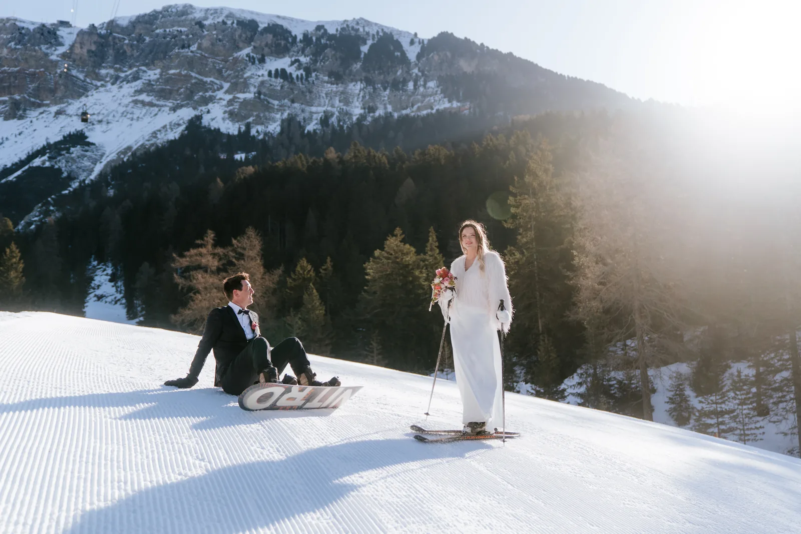 The groom sledging down a slope in his suit